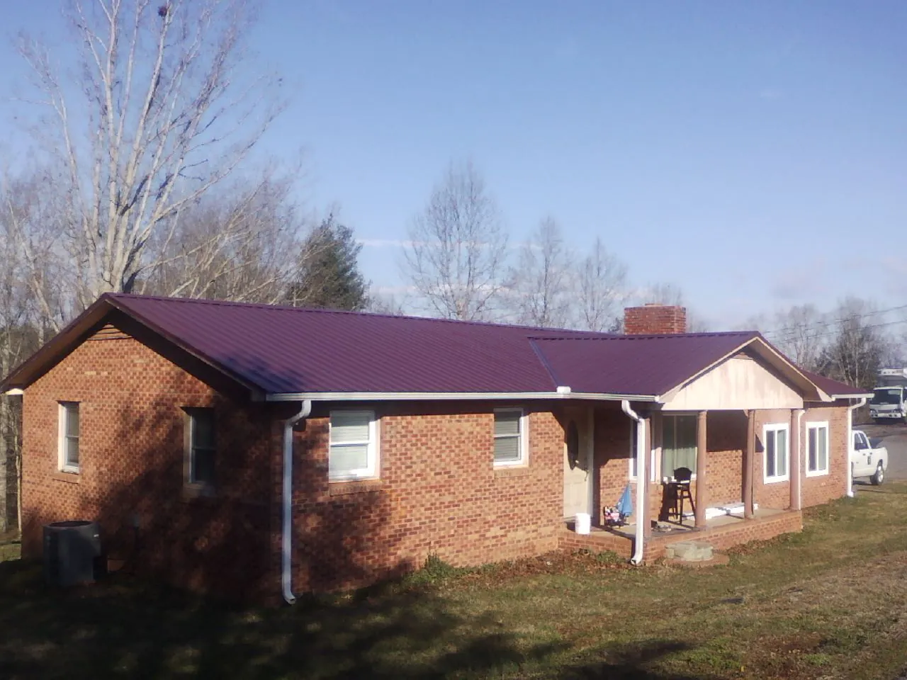 Burgundy metal roof on a brick ranch home with a new addition in Hamer