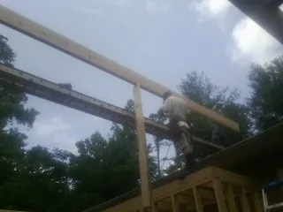 Carpenter setting a ridge beam over a new addition frame — Ice Dam Removal by Roofing Brothers in Hamer
